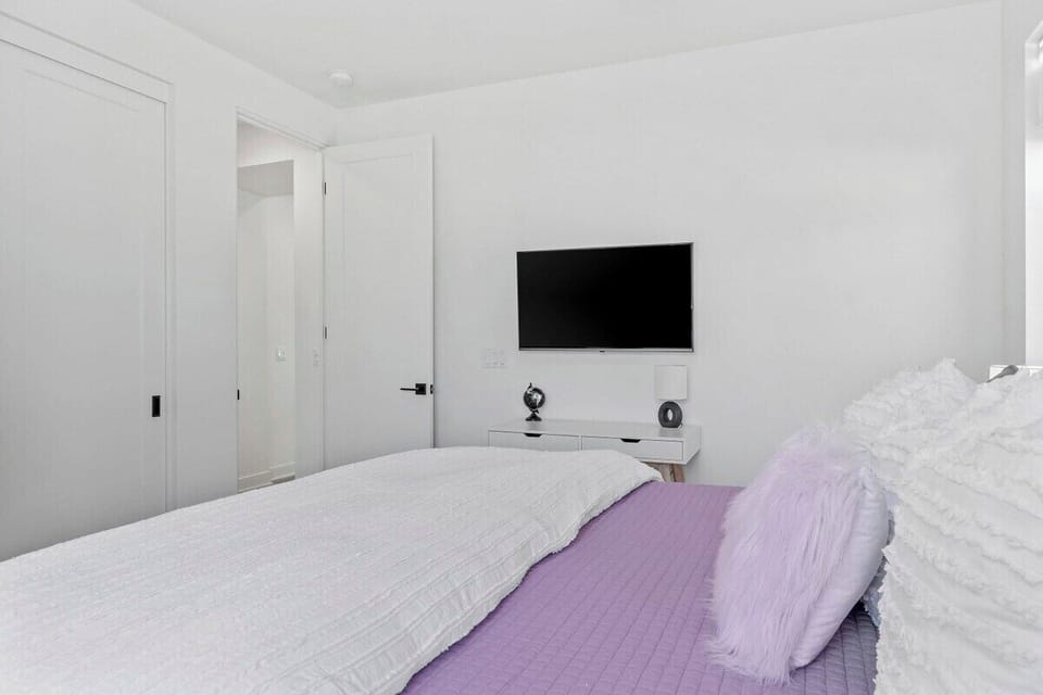 Second bedroom with wall-mounted TV.