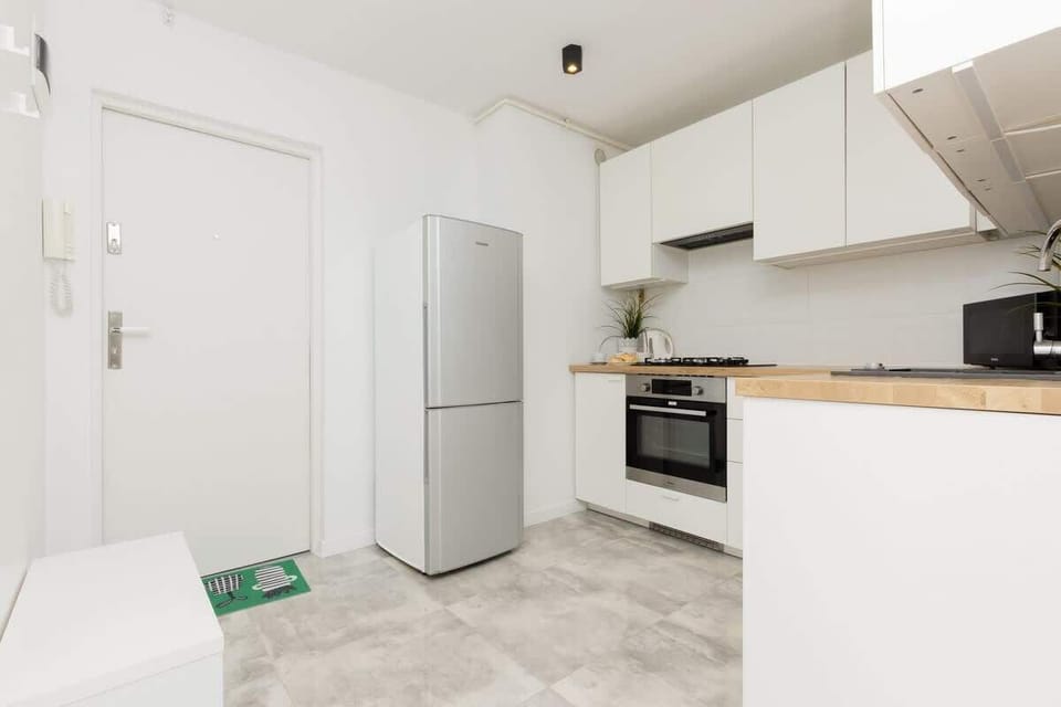 A wide-angle view of the kitchen, showing functional storage and a clean, minimalist design.
