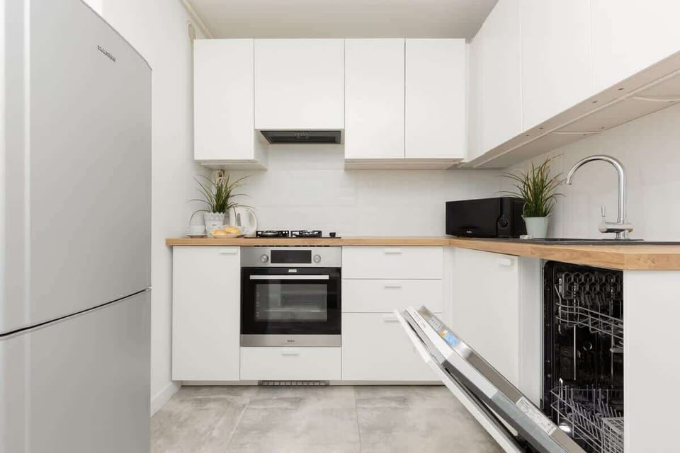 Another kitchen perspective, featuring a built-in oven, potted plants, and an organized layout.
