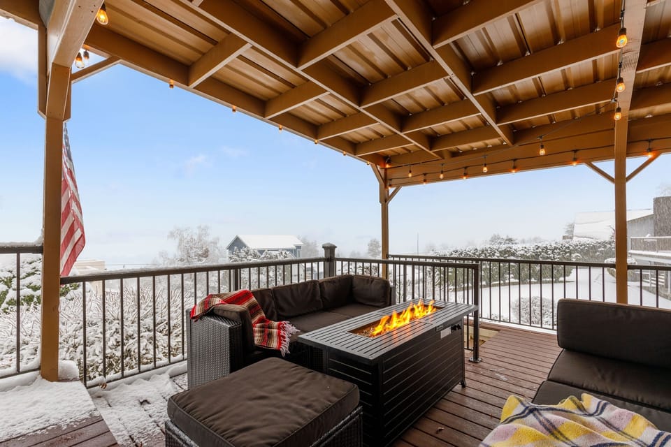 Winter vibes: Outdoor deck with lake views, lounge seating and hot tub