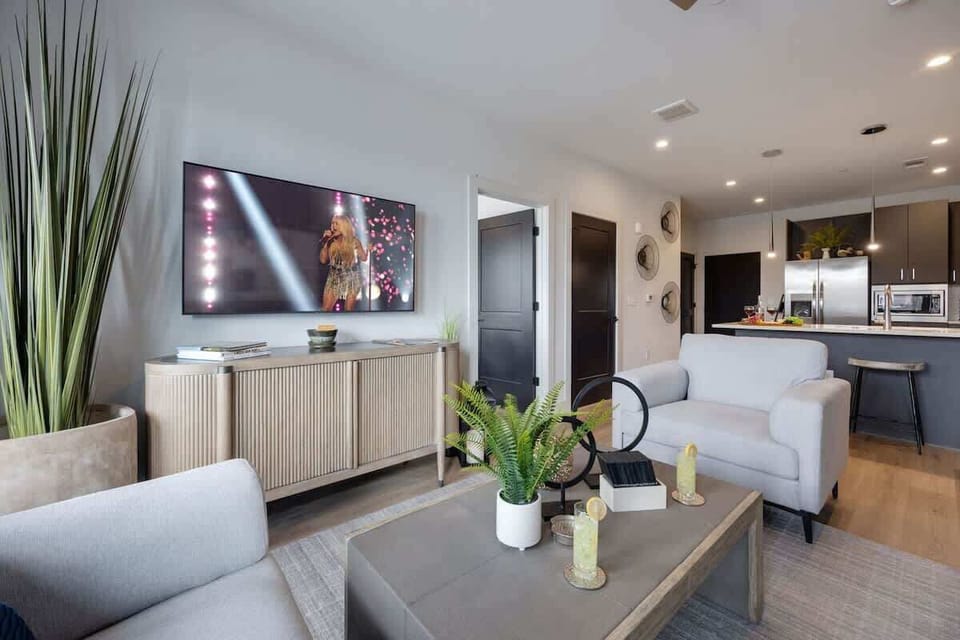 Bright open living space featuring SMART flat-screen TV, and designer furnishings throughout.