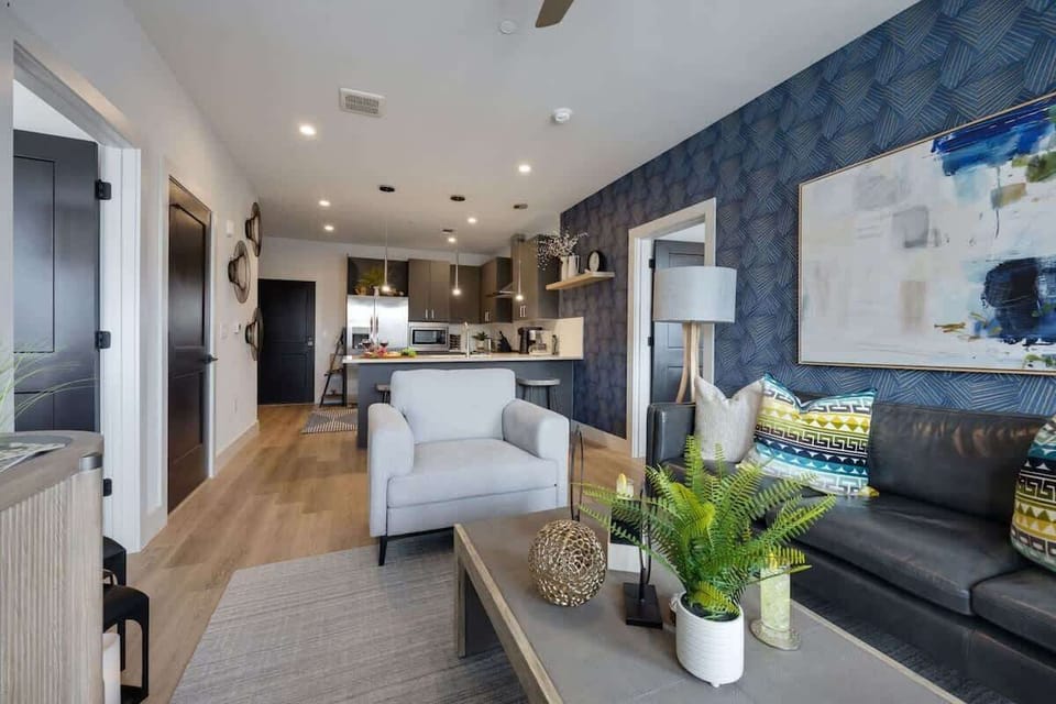 Bright open living space featuring SMART flat-screen TV, and designer furnishings throughout.