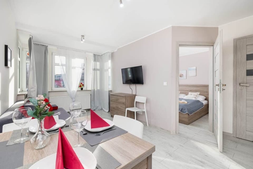 A different perspective of the open-plan living space, showing the dining area and TV.

