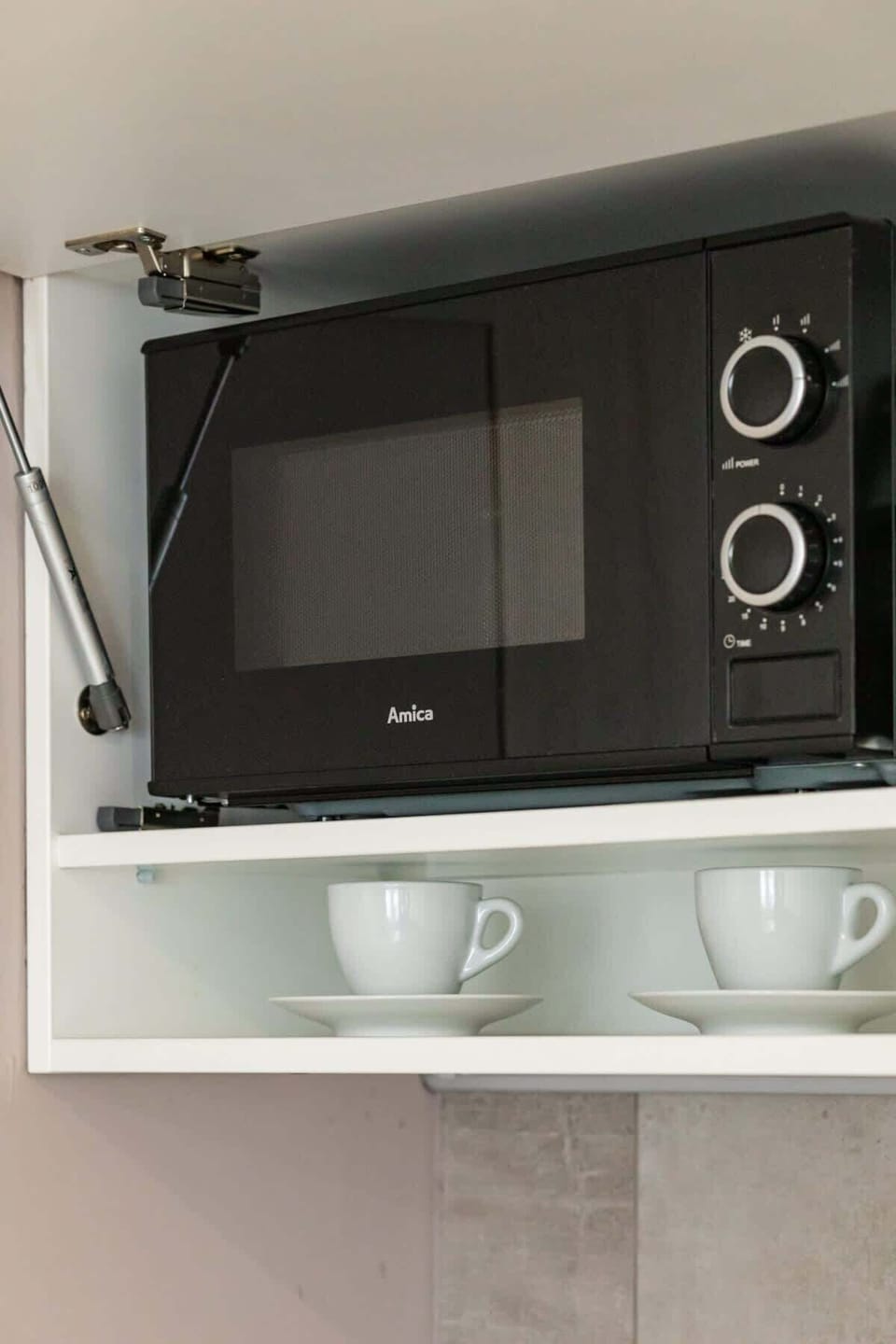 A microwave placed in a built-in kitchen shelf for space efficiency.







