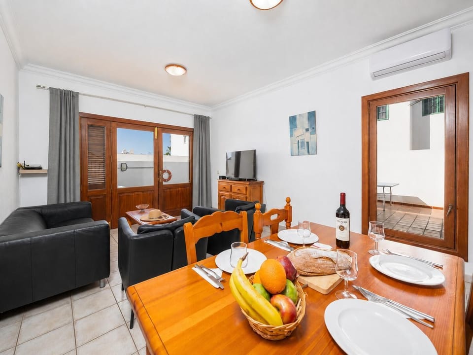 Living room with sofa, dining area, A/C, WiFi internet, and satellite TV