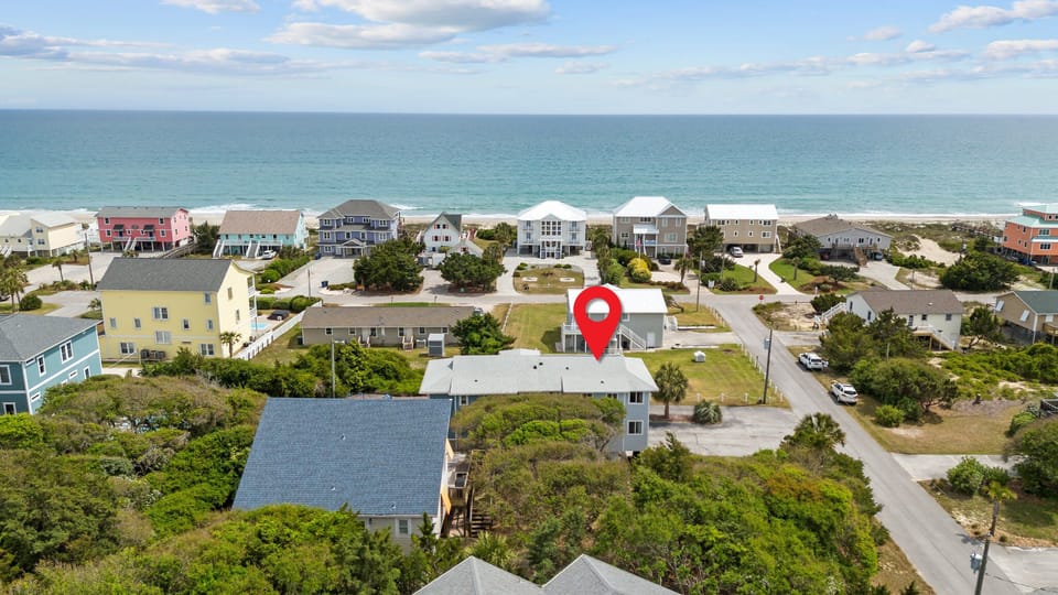 Coastal neighborhood aerial view showcasing oceanfront property location with nearby beach access and charming residential surroundings.