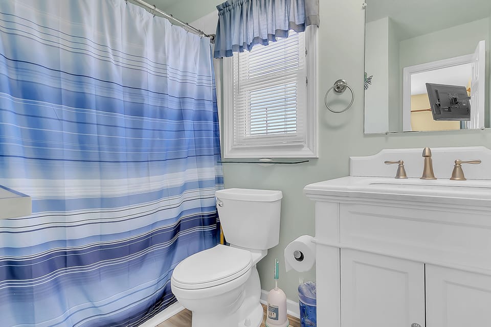 Your private bathroom features a refreshing shower, modern vanity, and coastal-inspired touches for your comfort.
