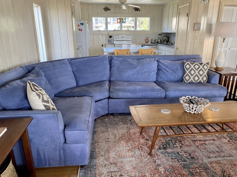 Sink into this plush blue sectional sofa where you can unwind after beach days, with your fully-equipped kitchen just steps away for easy meal prep.