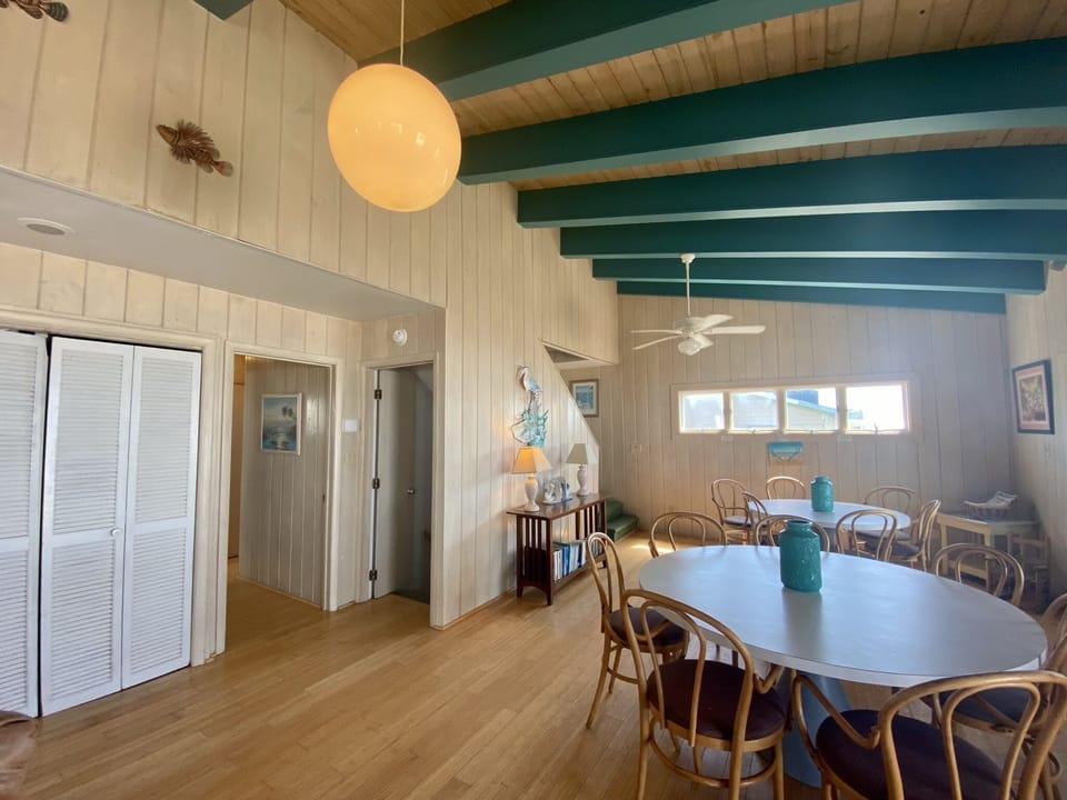 Gather with loved ones in this bright coastal dining room, where nautical touches and exposed teal beams create the perfect beach house vibe.