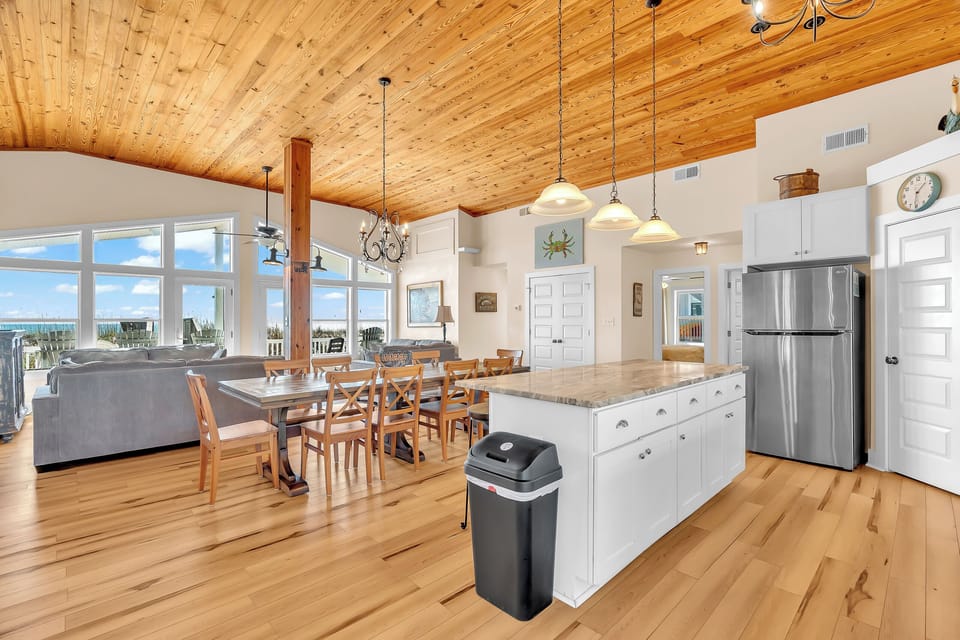 Gather in your spacious open-concept haven with soaring wood ceilings, modern kitchen island, and stunning windows that flood the space with natural light.