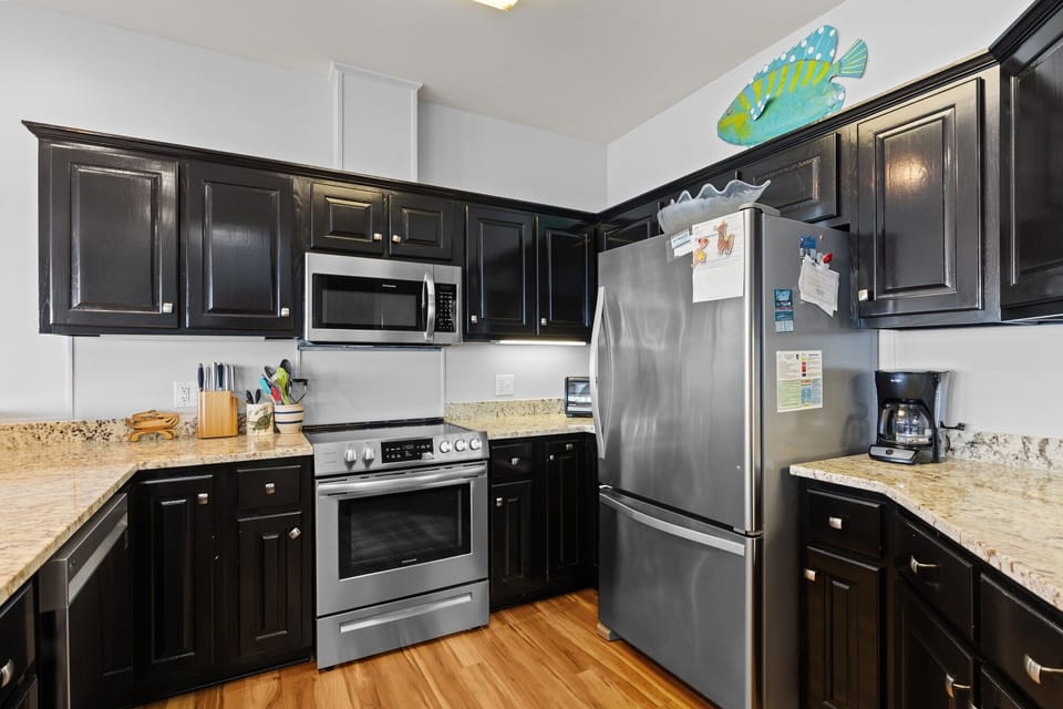 Your fully equipped kitchen features granite countertops, stainless steel appliances, and rich dark cabinetry—perfect for preparing memorable meals together.