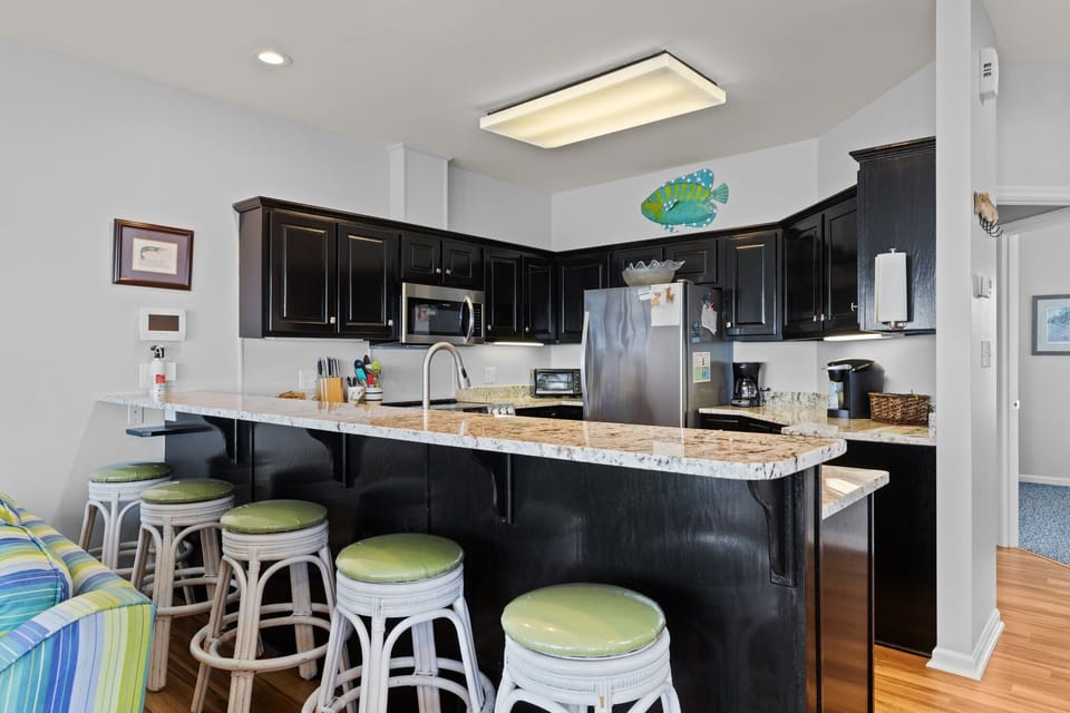 Your fully-equipped kitchen features elegant granite counters, modern appliances, and a breakfast bar where you'll savor morning coffee together.