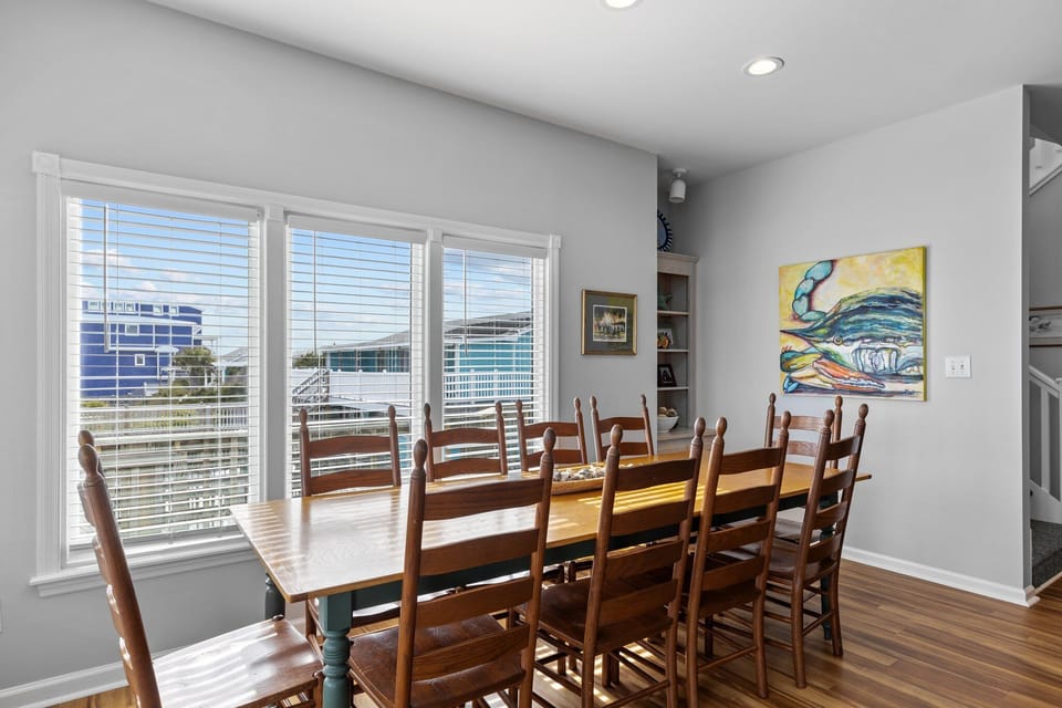Gather your group around this spacious dining table, where city views through large windows create the perfect backdrop for memorable meals together.