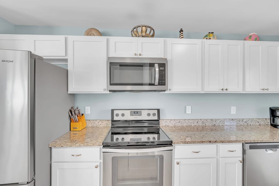 Your fully equipped kitchen features granite countertops, stainless steel appliances, and crisp white cabinetry—perfect for preparing meals during your stay.