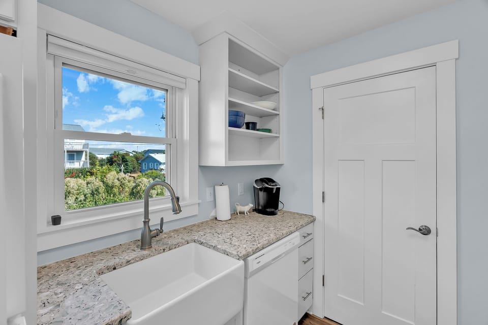Your bright kitchen nook features granite counters and coffee station, with peaceful garden views through the window.
