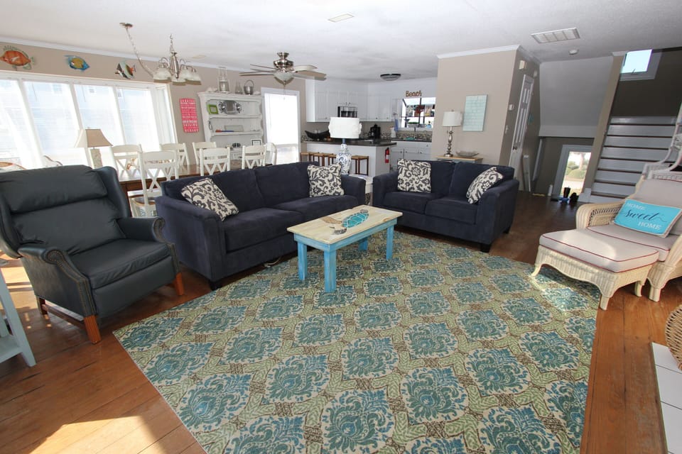 Unwind in your spacious living room with plush navy sofas and coastal charm, where natural light streams through large windows.