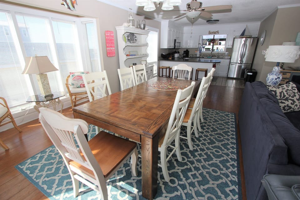 Gather around your spacious dining table where natural light streams through large windows, creating the perfect spot for family meals and morning coffee.