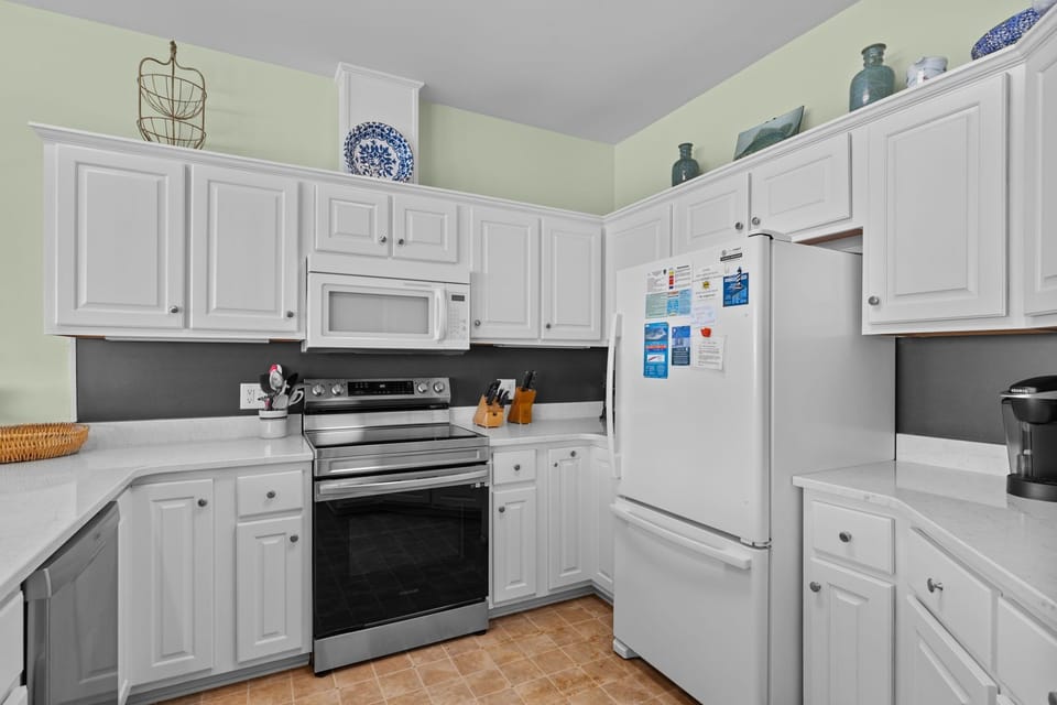 Your fully equipped kitchen features white cabinetry, stainless steel appliances, and ample counter space for preparing memorable meals during your stay.