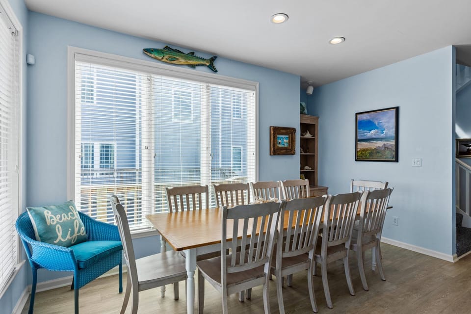 Gather your group around this spacious dining table where beach-themed décor and cheerful blue walls create the perfect coastal atmosphere for memorable meals together.