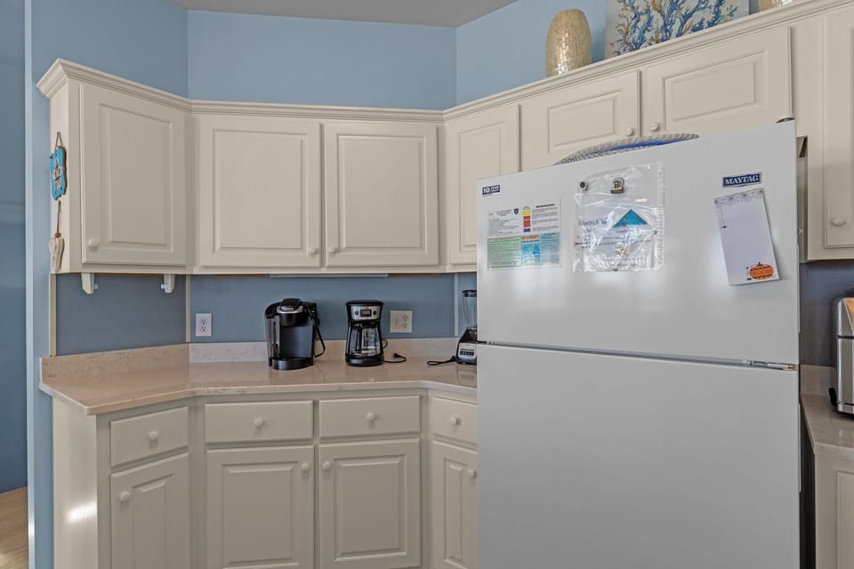 Your fully equipped kitchen features white cabinets, coffee maker, and all essentials for preparing meals during your stay.