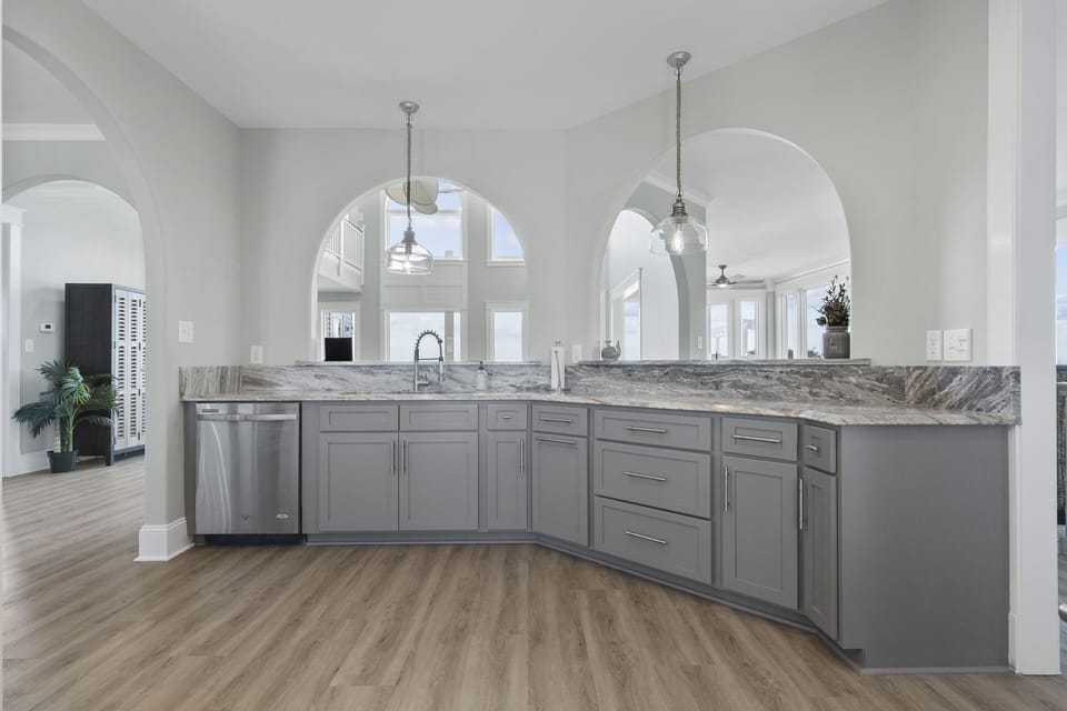 Your chef's dream awaits with gleaming granite counters, stainless steel appliances, and elegant pendant lighting in this sophisticated kitchen space.