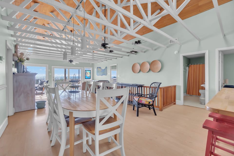 Gather around the dining table under soaring white beams while ocean breezes flow through your bright, airy retreat.
