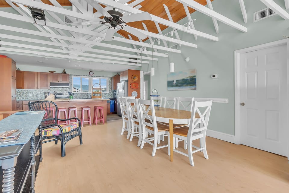 Unwind in your spacious open-plan living area where cathedral ceilings and soft coastal colors create the perfect atmosphere for family meals and relaxation.