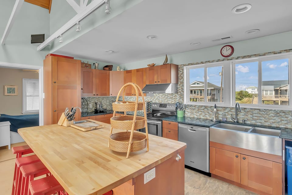 Your fully equipped kitchen awaits with stainless steel appliances, spacious island, and sunny windows overlooking the neighborhood.