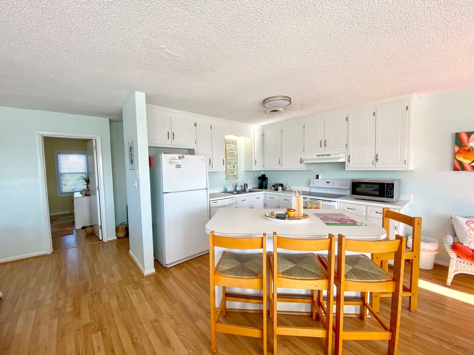 Your bright kitchen features white cabinets, modern appliances, and a cozy dining area where you can enjoy meals together.