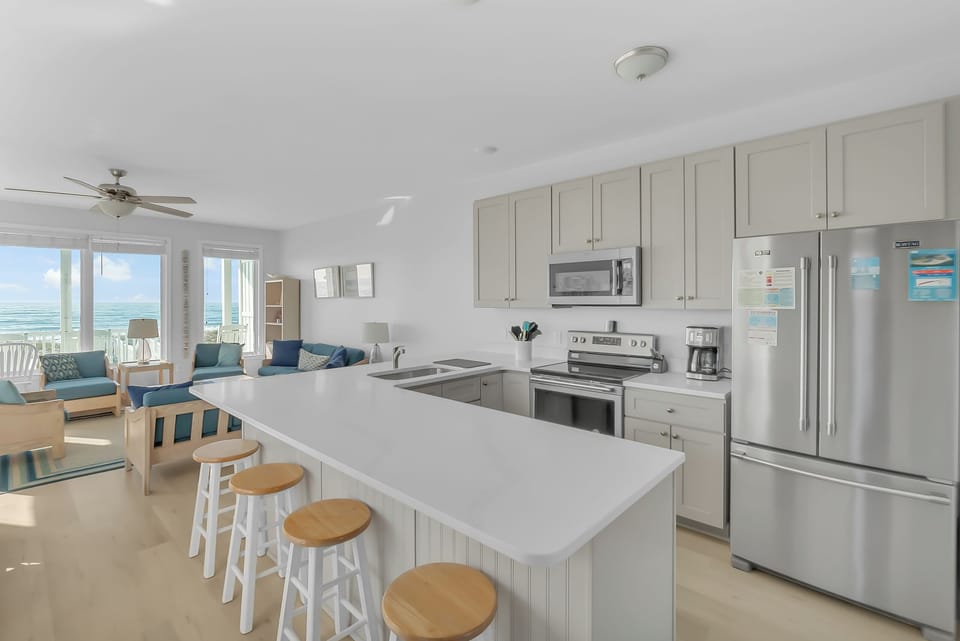 Your bright, open kitchen flows seamlessly to the living area, where stunning ocean views create the perfect backdrop for memorable meals.