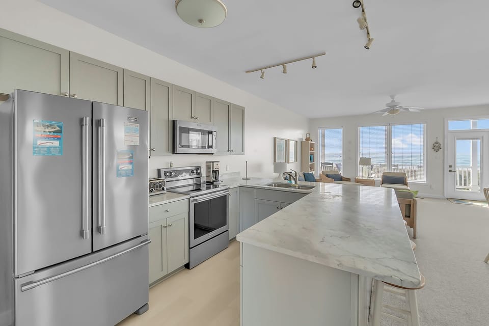 Your fully-equipped gourmet kitchen flows seamlessly into the living area, perfect for preparing meals while enjoying ocean views.