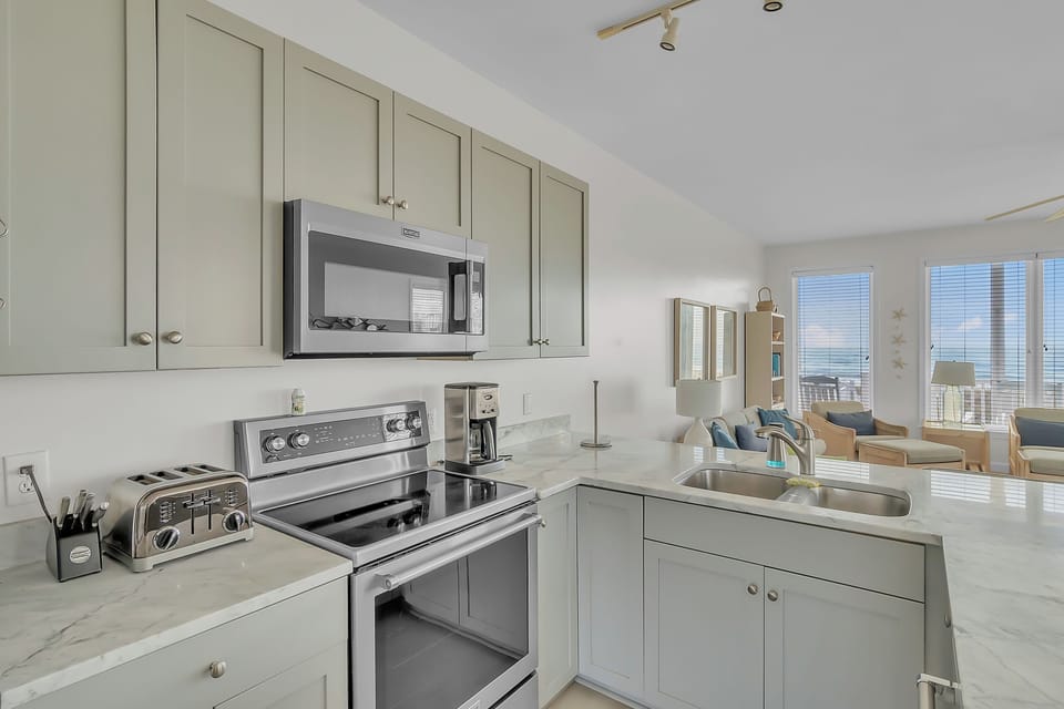 Cook your favorite meals in this fully equipped kitchen, complete with modern appliances and marble countertops overlooking your inviting living space.