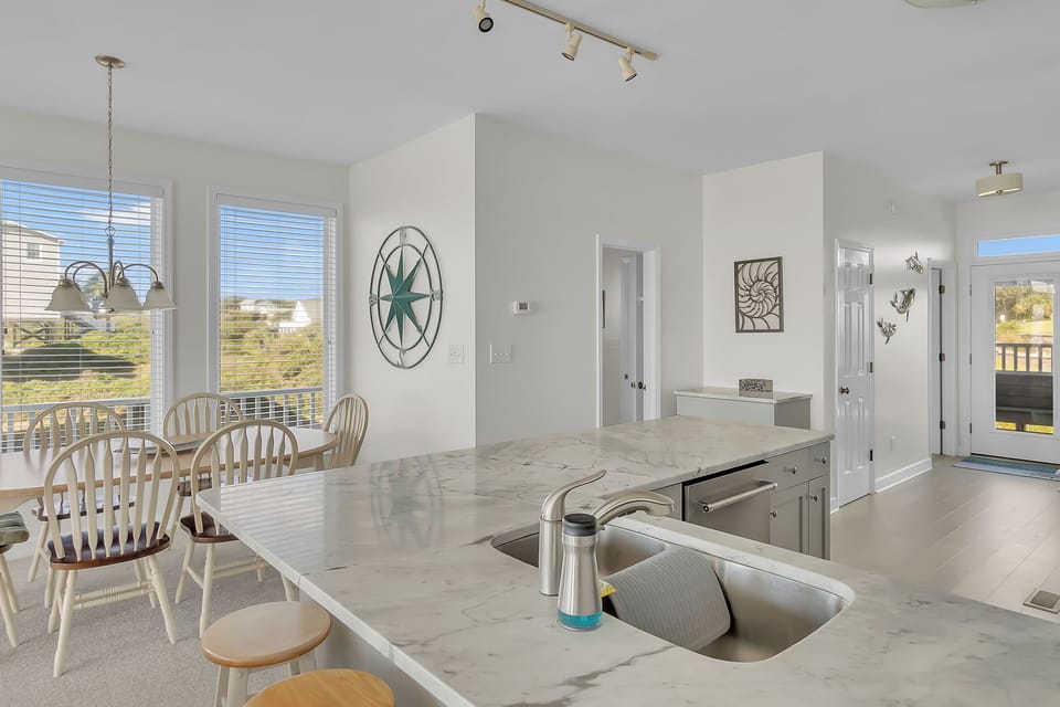 Your spacious kitchen island becomes the heart of your stay, where marble countertops and modern appliances invite memorable meal prep with stunning views.