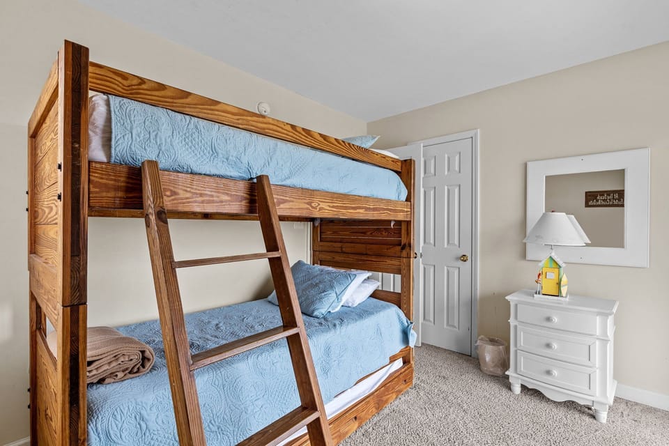 Your kids will love this cozy bunk bed room with sturdy wooden bunks and soft blue bedding for perfect sleepover adventures.