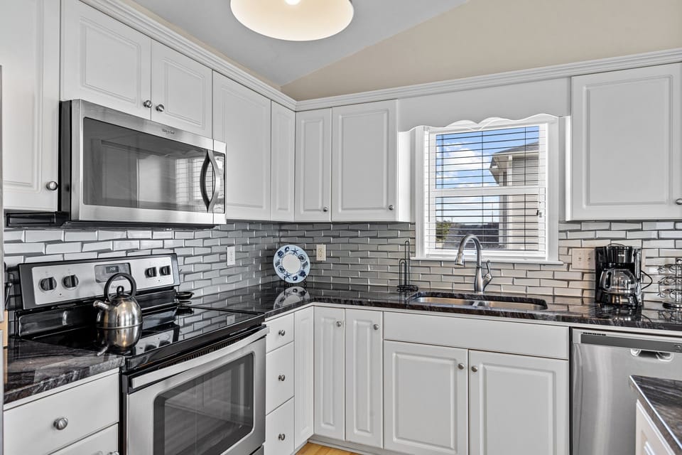 Your fully equipped kitchen features elegant white cabinets, granite counters, and stainless appliances for effortless meal preparation.