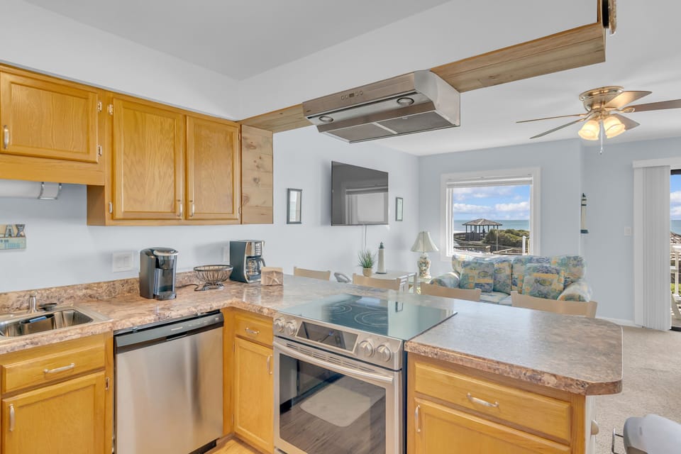 Cook with ocean views through your kitchen window, complete with modern appliances and warm wooden cabinets for a truly relaxing culinary experience.