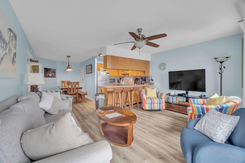 Unwind in this bright, open-concept space where soft blues meet warm wood tones, creating your perfect beach getaway retreat.
