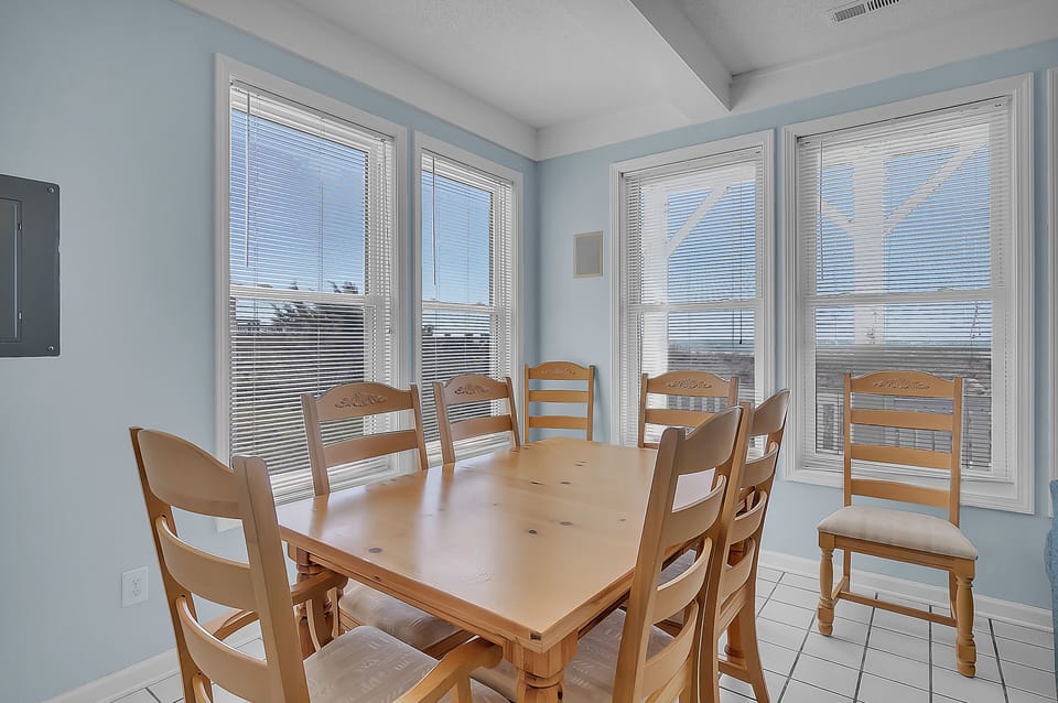 Gather around this welcoming dining table where morning coffee and evening conversations flow naturally in your bright, sunlit space.