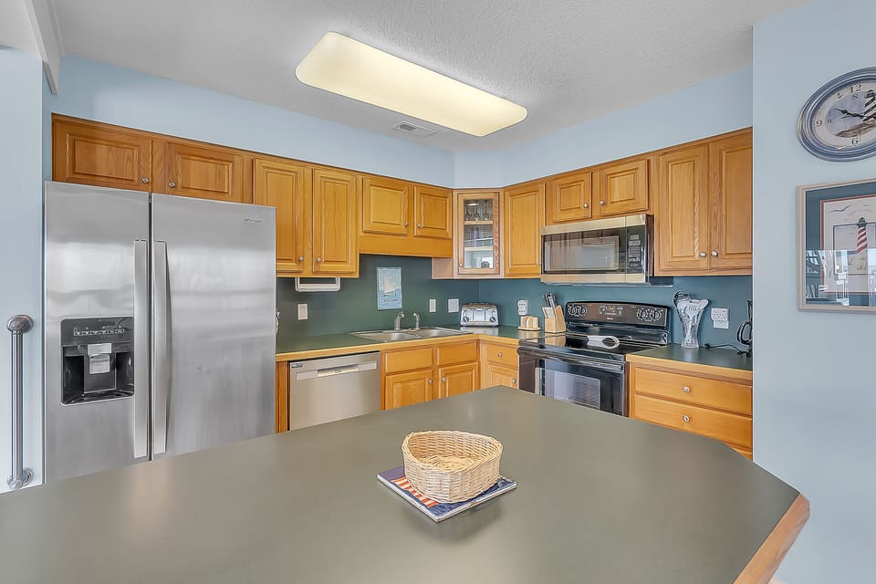 Your fully equipped kitchen welcomes you with warm wood cabinets, modern stainless steel appliances, and plenty of counter space for preparing meals.
