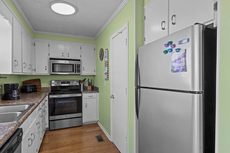 Your fully equipped kitchen features stainless steel appliances and bright green walls, perfect for preparing meals during your stay.