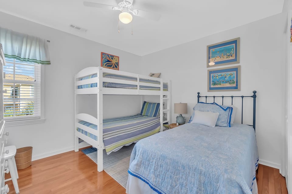 Cozy blue-themed bedroom with bunk beds and single bed, perfect for families with children.