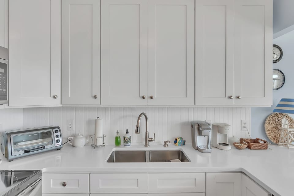 Your fully equipped kitchen awaits with modern appliances and crisp white cabinetry for memorable meal prep.