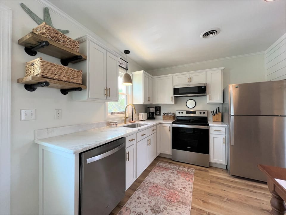 Your fully equipped kitchen invites culinary adventures with modern appliances, quartz countertops, and charming rustic shelving for all your cooking essentials.