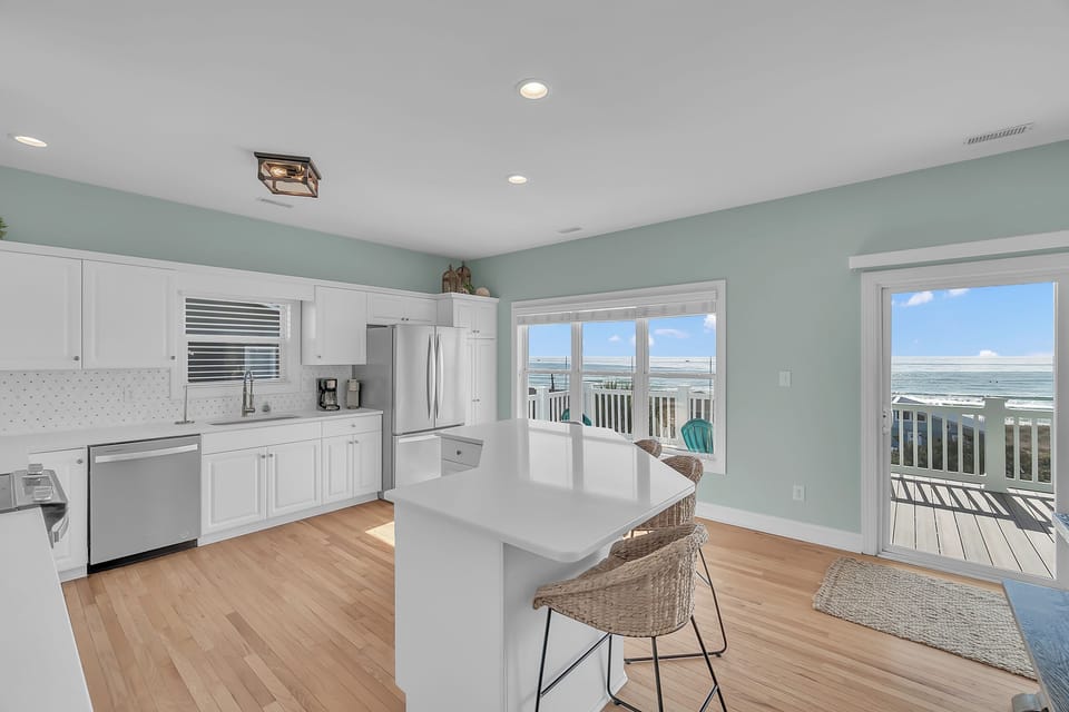 Your bright coastal kitchen features ocean views, modern appliances, and a breakfast bar perfect for morning coffee with sea breezes.