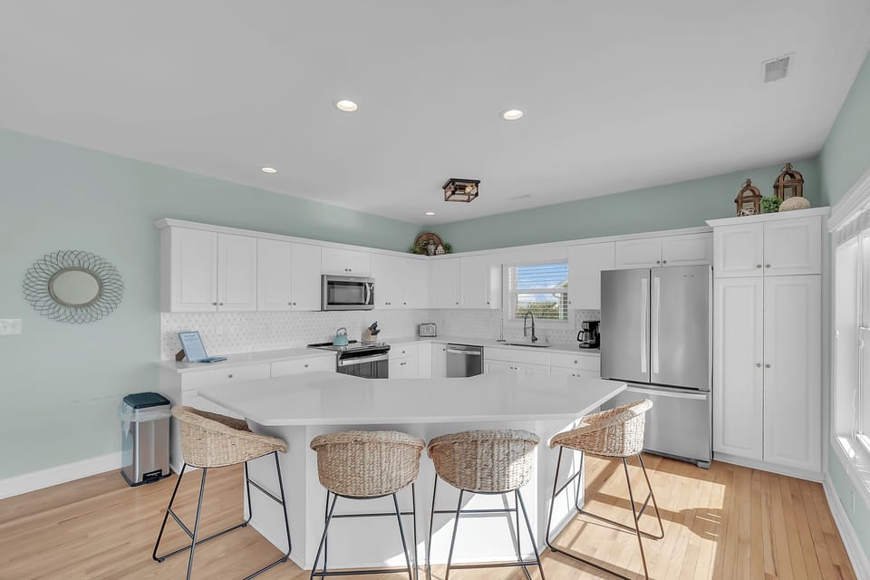 Your spacious kitchen features white cabinetry, modern appliances, and a large island where you can gather for meals and conversation.