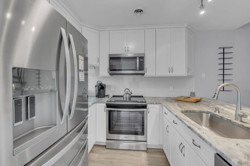 Your modern kitchen features sleek white cabinets, granite countertops, and stainless steel appliances for effortless meal preparation.