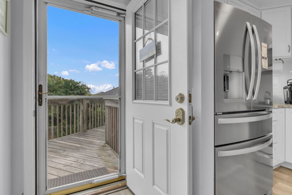 Step from your bright kitchen onto your private deck and soak in peaceful treetop views through the open door.