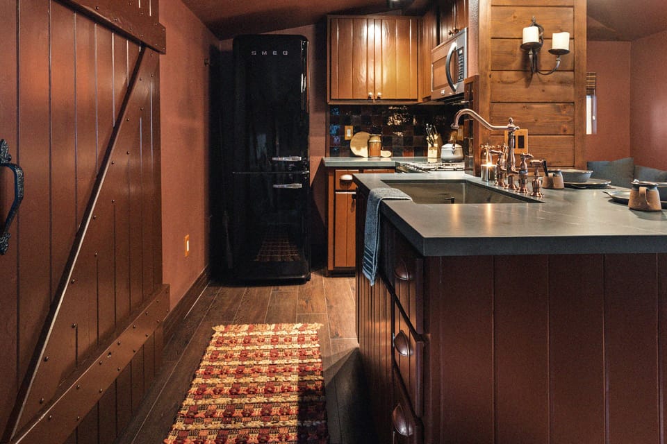The full kitchen features a Smeg fridge, stove, microwave, pots & pans, dishes, and utensils for cooking meals in your cabin. (Or to make coffee or tea!)