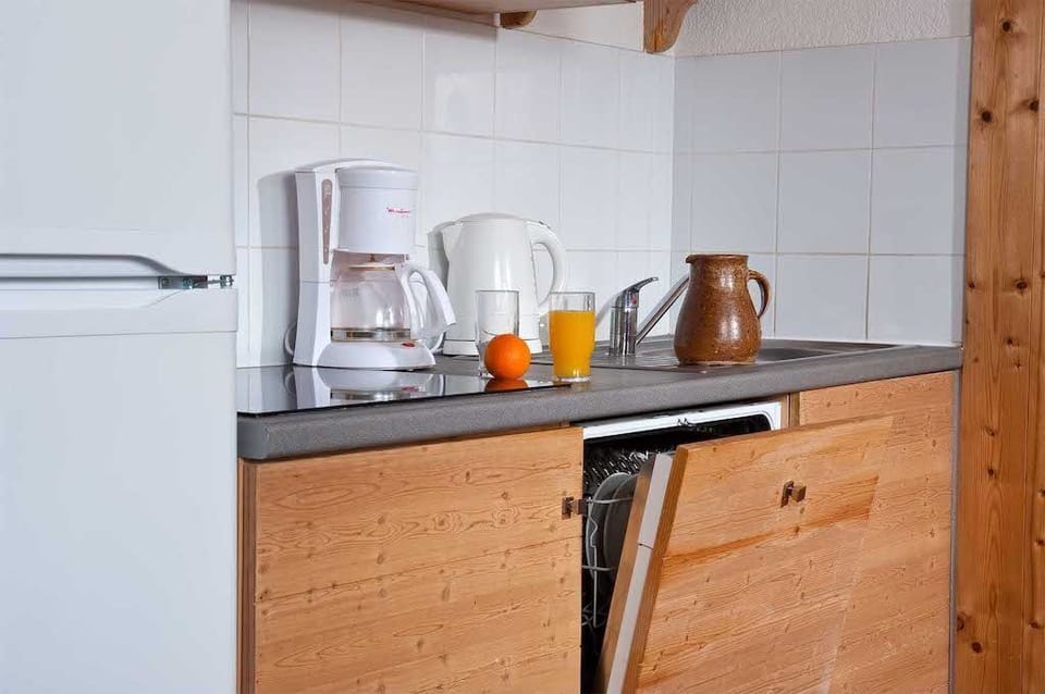 A well-equipped kitchen showcases a blend of modern appliances and rustic wooden cabinetry, inviting guests to prepare warm meals after a day on the slopes.