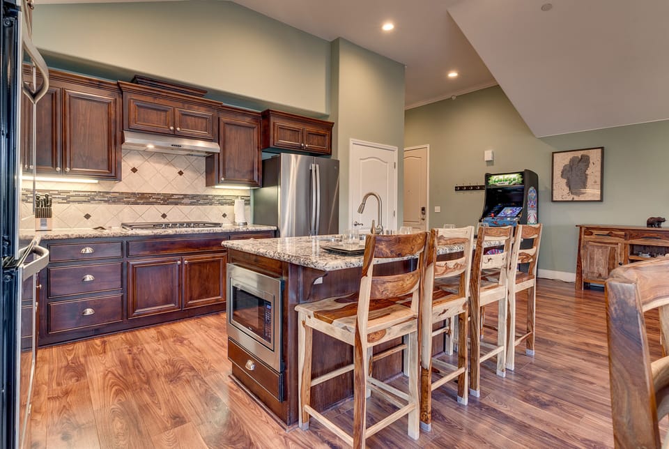 - Modern kitchen with granite counters  
- Stainless steel appliances and wood cabinets  
- Vacation rental kitchen with island seating